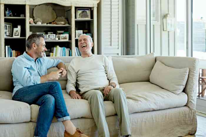 Father and son laughing on a sofa