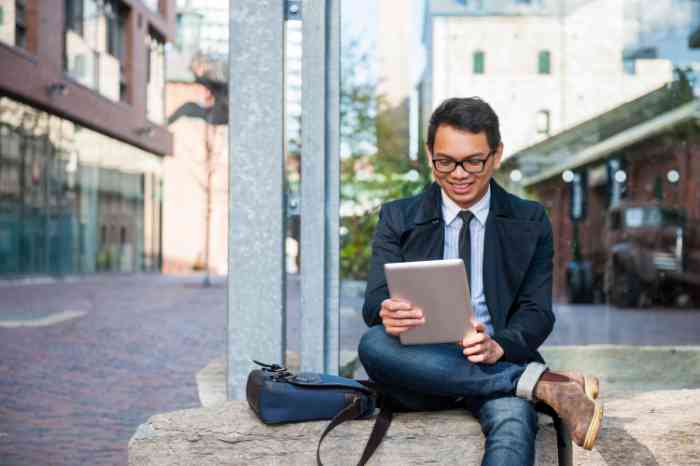 Asian man reading blog on tablet