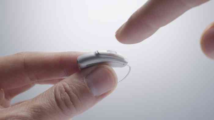 Hand holding a BTE hearing aid