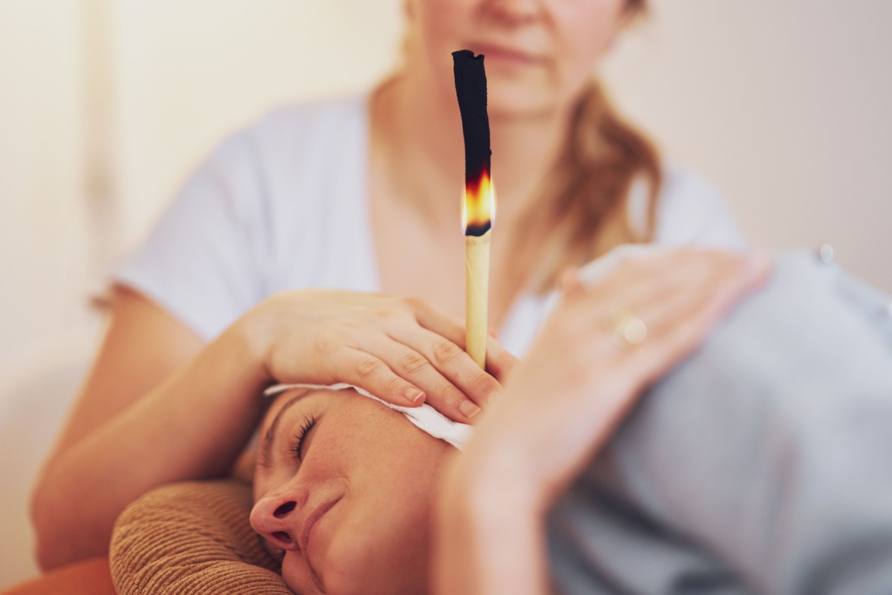 a woman put a candle on the ear of another woman