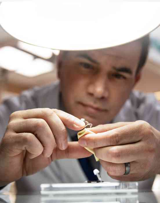 Person handling hearing aid device