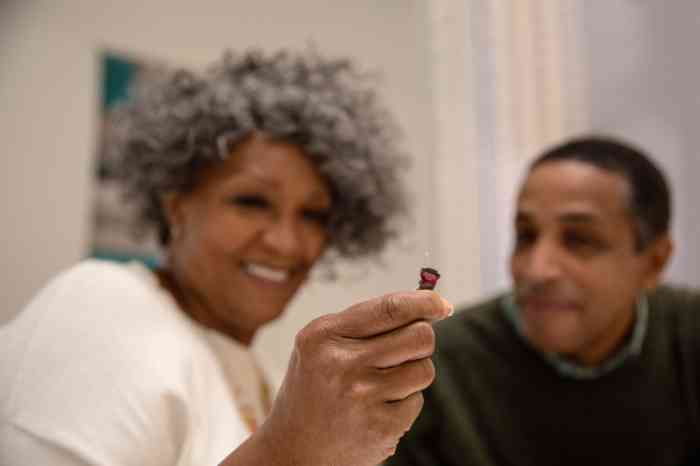 Couple holding up hearing aid