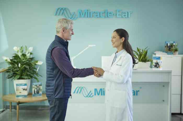 man shaking hands with a hearing care specialist