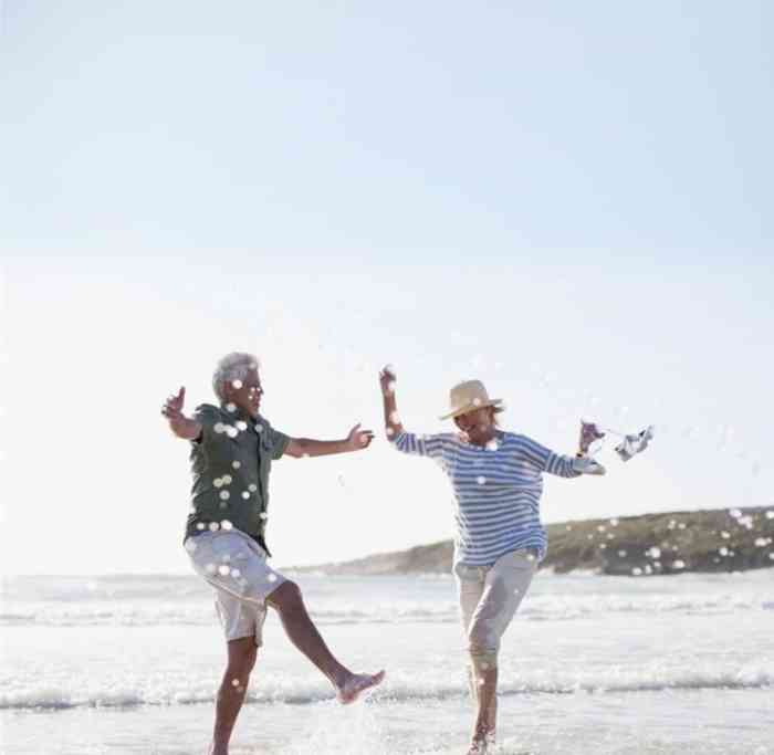 Couple splashing in water and playing on the beach.