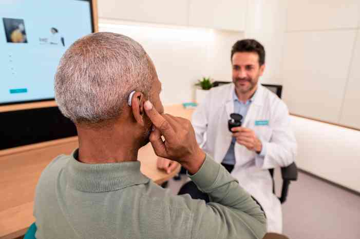 Man trying on a hearing aid