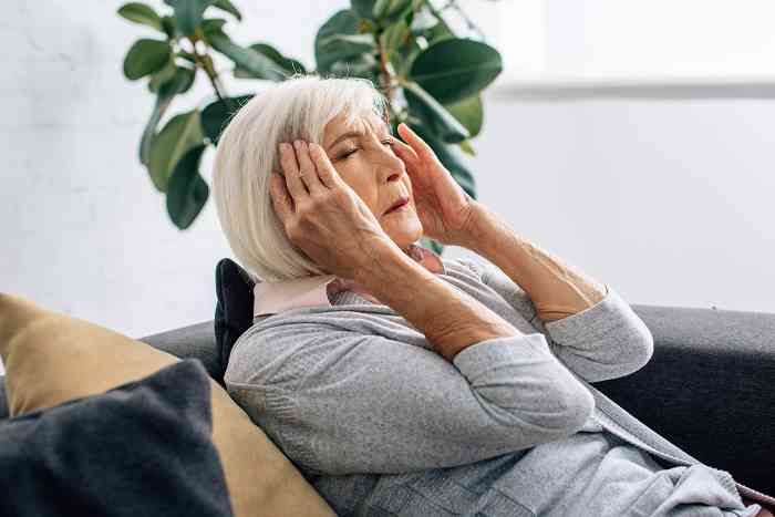Old woman with pain behind the ear