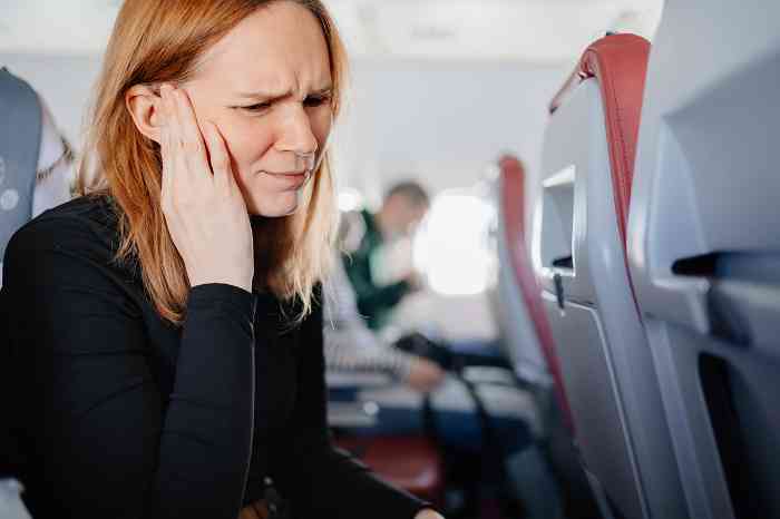Woman on the airplane with ear pain