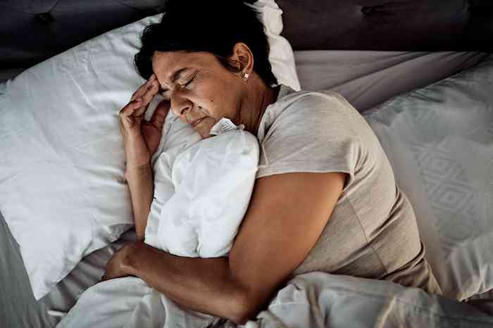 Woman in bed with headache