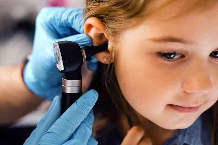 A little girl has her ear checked