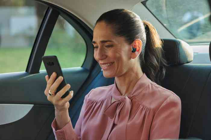 Woman with phone & hearing aid
