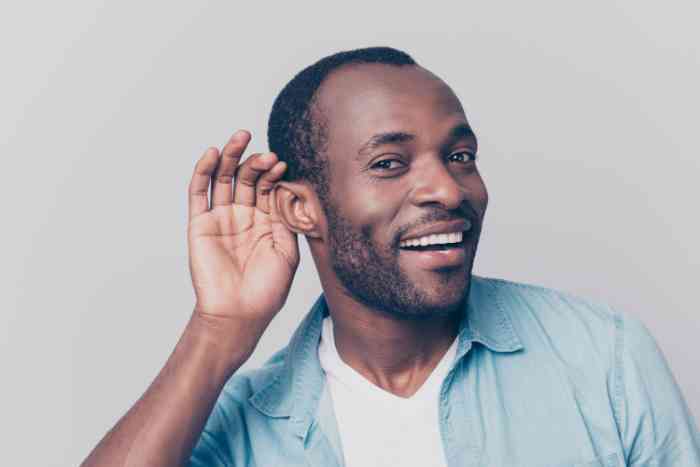 Smiling man with a hand on his ear
