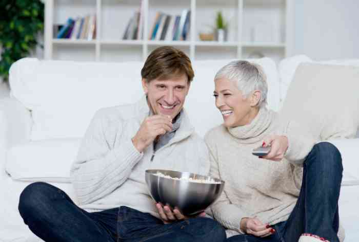 Couple watching TV and eating pop corn