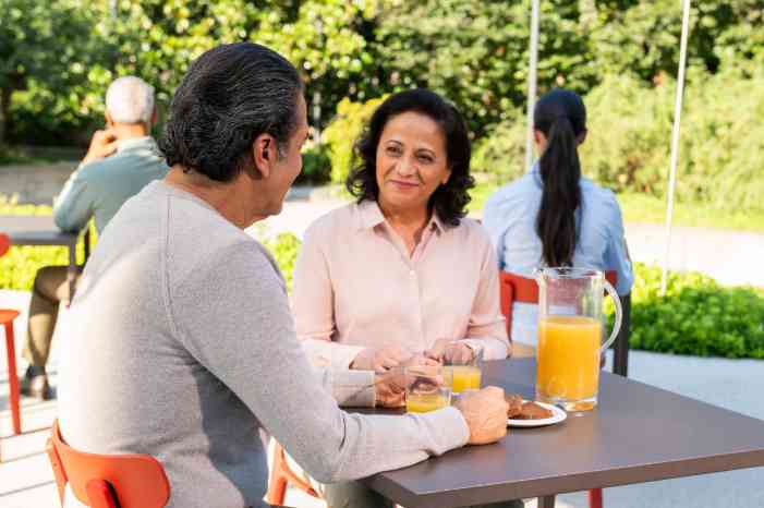 latin male client female caregiver breakfast in park