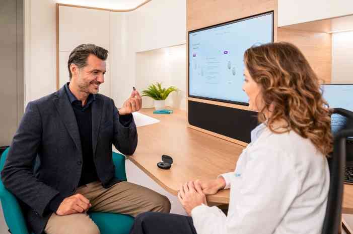 male wearing a hearing aid and audiologist in store