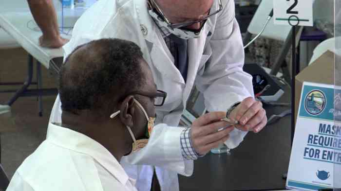 Hearing care specialist showing gift of sound recipient new hearing aids