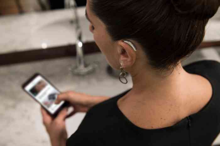 man wearing hearing aids and using the Miracle-Ear app
