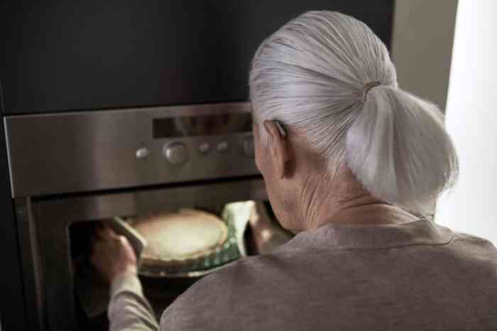 Woman putting pie in the oven 