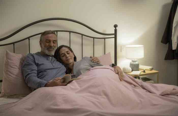 Elderly couple hugging in their bedroom