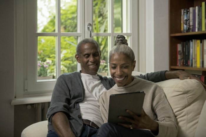 couple on sofa looking at tablet