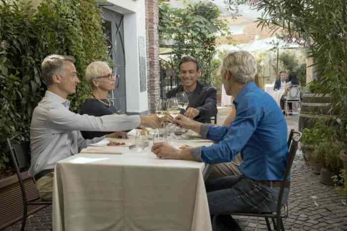 Friends having dinner and making a toast with glasses of white wine