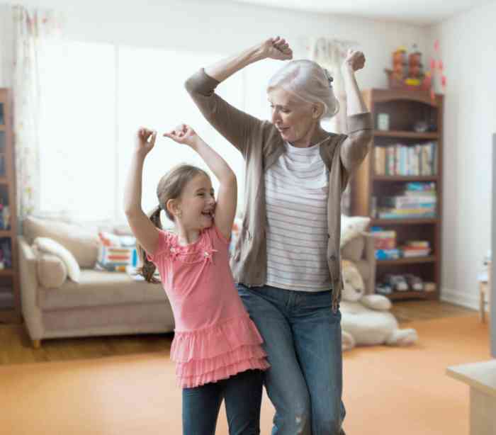 An elderly woman and her granddaughter dancing together