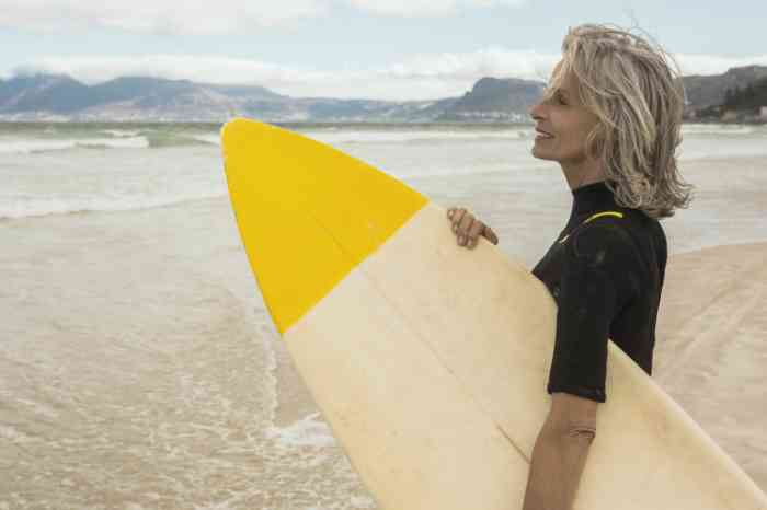 Woman holding a surf board at the beach