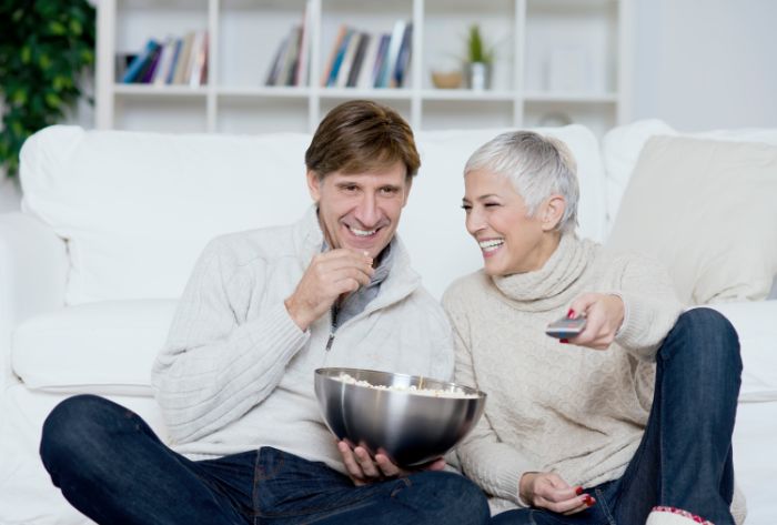 Couple watching TV and eating pop corn