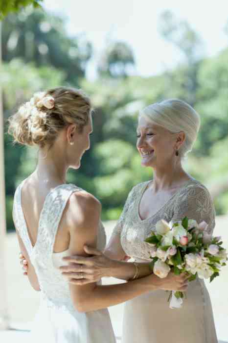 A bride and mother hugging at her wedding
