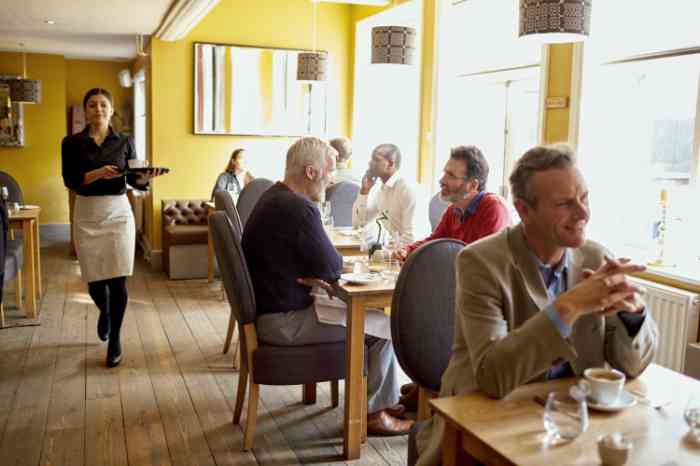 Friends making a toast in a restaurant with glasses of white wine