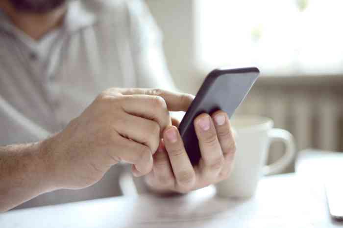 A man scrolling a page on his smartphone 