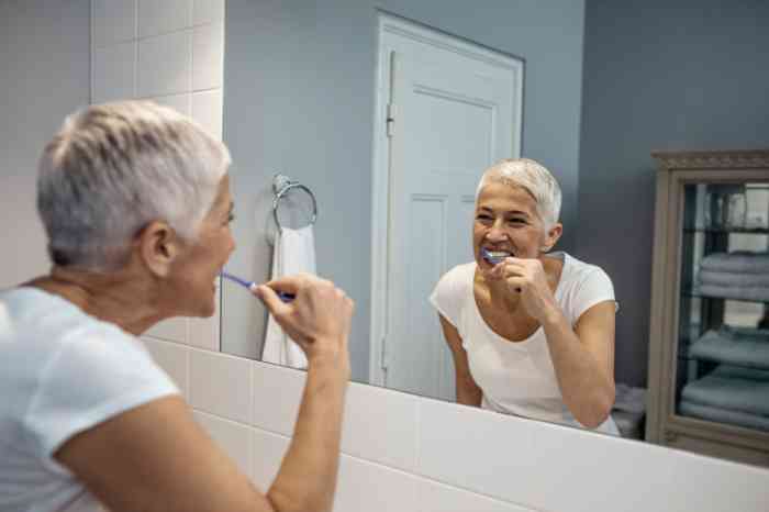 Woman in a bathroom washing her teeth 