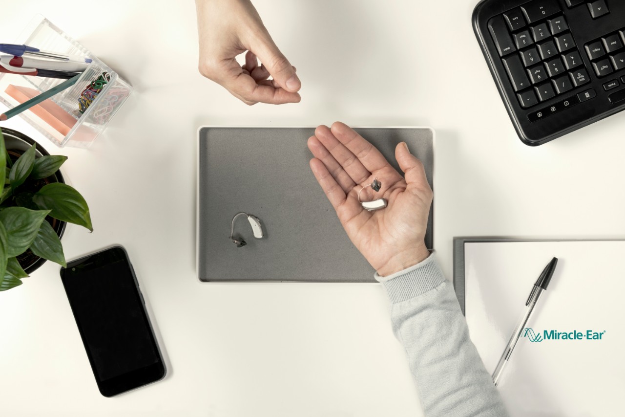 RIC hearing aid in the palm of a hand