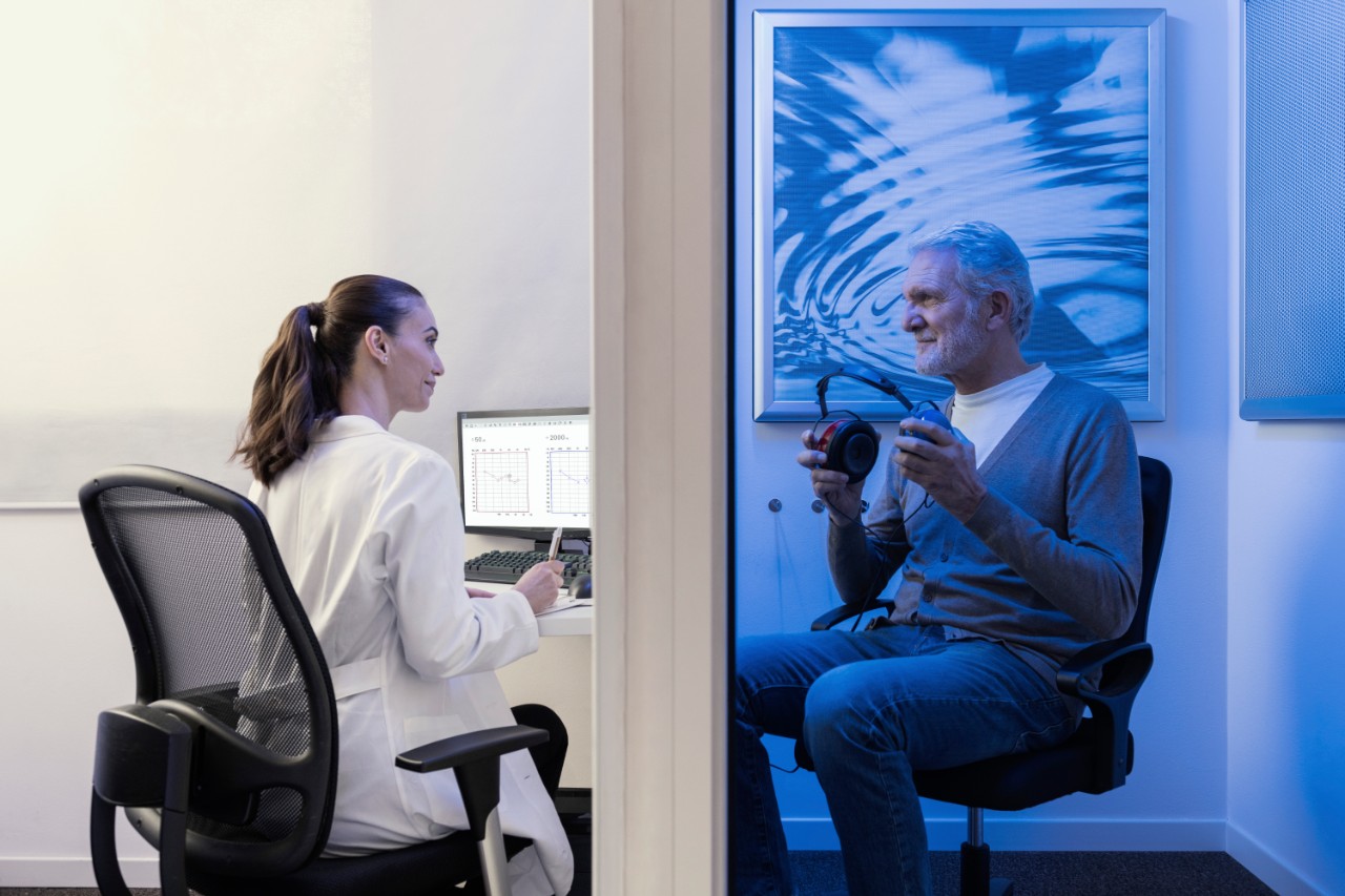 Miracle-Ear audiologist and an elderly man with headphones during a hearing test