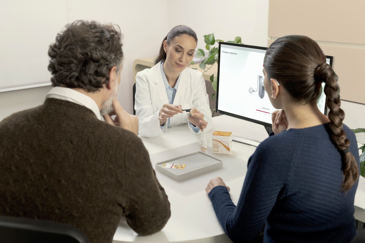 HCP showing patients how to clean hearing aids