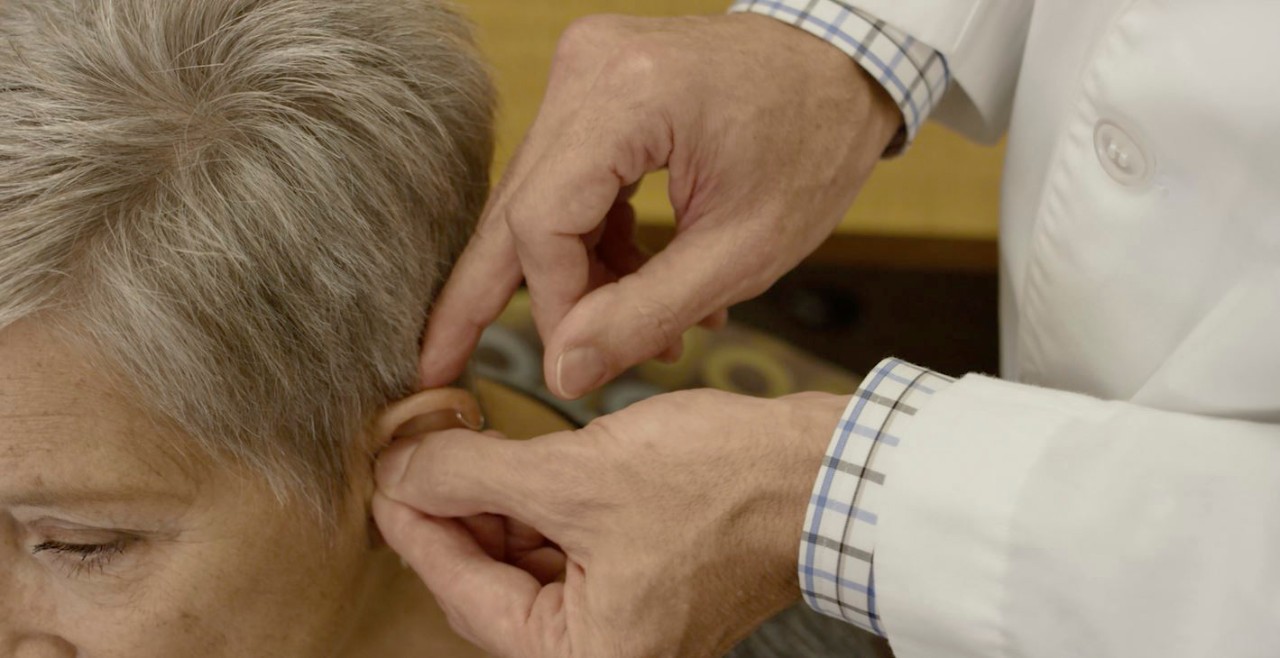 HCP John helping patient with hearing aid