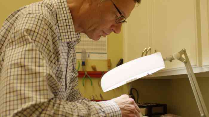 Hearing instrument specialist repairing a hearing aid