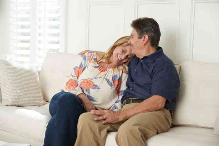 Miracle-Ear customer hugging with her husband on the sofa