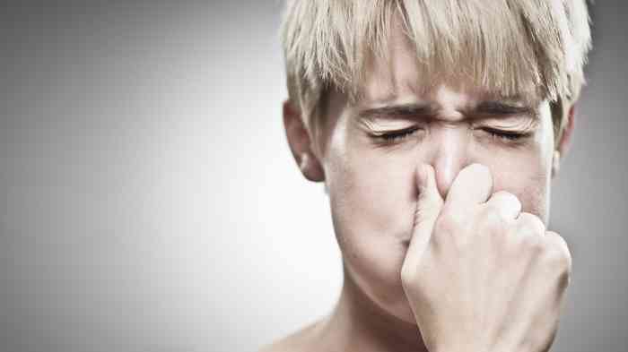 Woman pinching her nostrils while breathing out