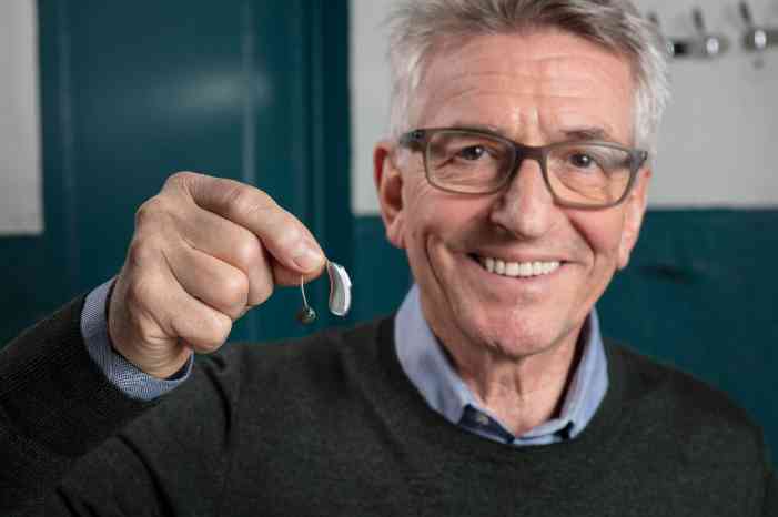 Man showing a hearing aid