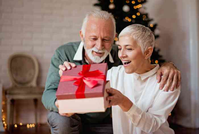 couple opening a present by the christmas tree