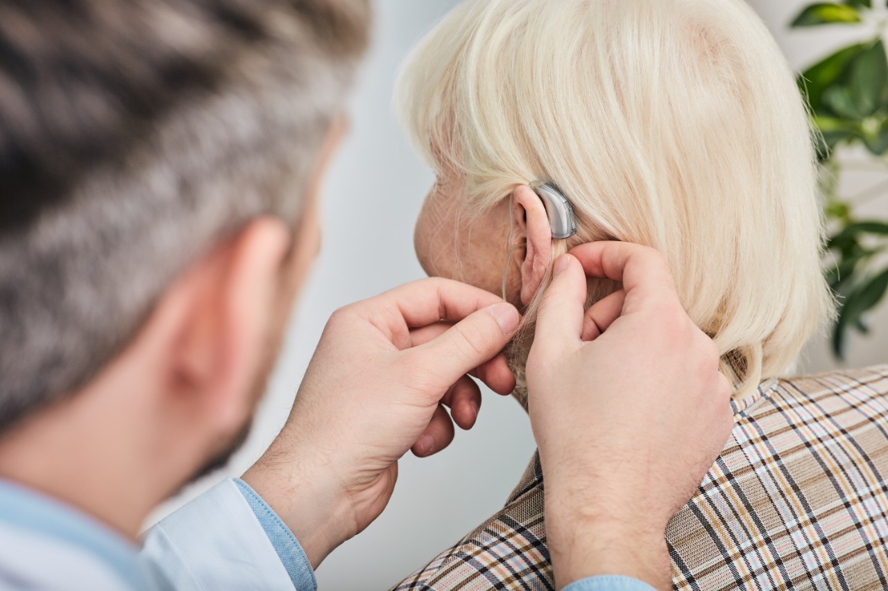 Doctor placing a hearing aid