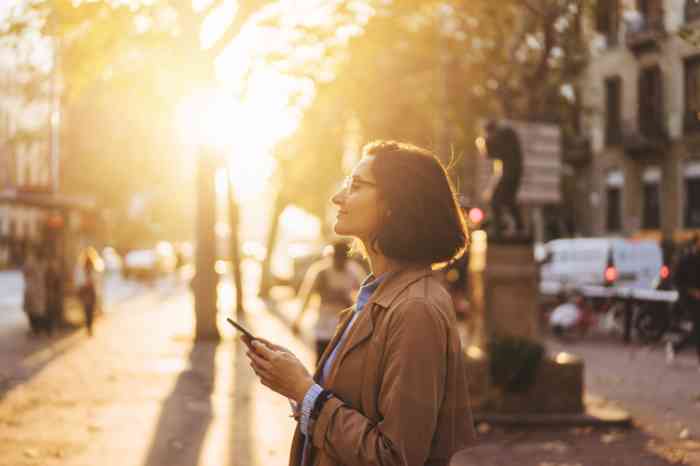 woman on mobile phone outdoors accessing hearing app