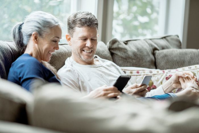 senior couple sitting at the table looking at laptop
